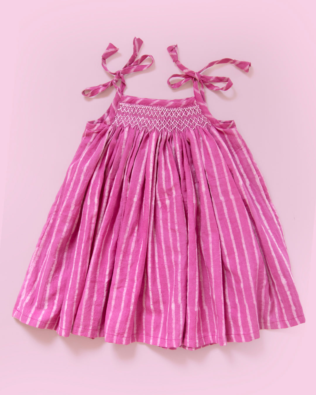 Hand-smocked Jaipur cotton baby dress in taffy pink stripe with tie-up shoulders for newborn girls by MyBud